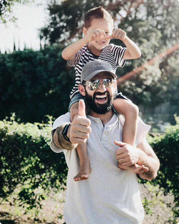man with kid on shoulders