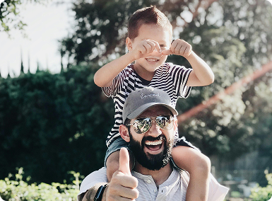 man with kid on shoulders